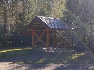 a gazebo with a roof in the grass at OSADA ŚWIERKOWA in Kopalino