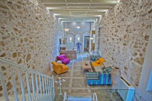 a living room with colorful furniture and a stone wall at Thalassa Boutique Hotel in Rethymno