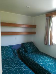 a bedroom with two beds and a window at Les chalets de Bes Le Montagnol in Lacombe