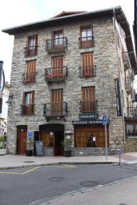 a stone building with windows and balconies on a street at Pensión Lagunak in Zarautz