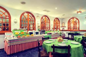 un restaurant avec des tables et des nappes vertes dans l'établissement Hotel Museo Los Infantes, à Santillana del Mar