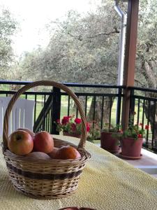 a basket of apples sitting on a table on a porch at Lucky Farm House in Potamia