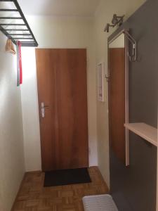 a bathroom with a shower and a wooden door at Haus Alpenkönig Top 17 in Bad Gastein