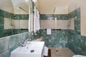 a bathroom with a sink and a shower at Locanda Di San Martino Hotel & Thermae Romanae in Matera