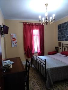 a bedroom with two beds and a table and a window at La Corte di Lucina in Terralba