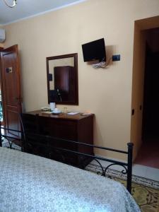 a bedroom with a bed and a mirror and a television at La Corte di Lucina in Terralba