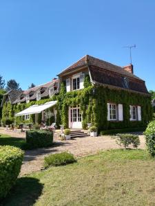 a house covered in ivy on top of a yard at Maison Angulus Ridet in Montcresson