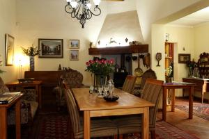 a dining room with a wooden table with flowers on it at Centre-Ville Guest House in Franschhoek