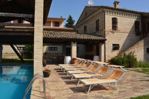 a row of lounge chairs sitting next to a pool at La casa nella Vigna in Montegranaro