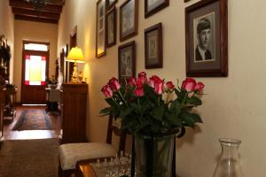 Franschhoek的住宿－威利之心旅館，一张桌子上装满粉红色玫瑰的花瓶