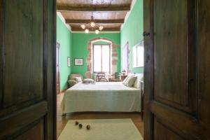 um quarto com paredes verdes e uma cama num quarto em B&B S'Asilo Sardegna em Banari