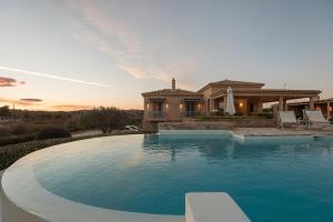 a house with a swimming pool in front of a house at Villa Emerald in Porto Heli