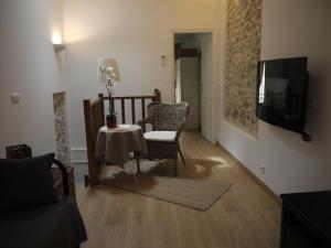 a living room with a table and chairs and a television at Vieille Ville 2 - La Petite Maison à Safranier, 2 bedrooms, max 4 adults and 2 kids in Antibes