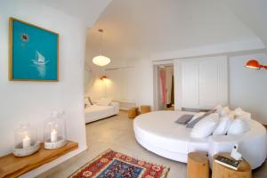 a large white bedroom with a large white bed at Santorini Secret Suites & Spa, Small Luxury Hotels of the World in Oia