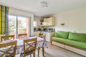 uma sala de estar com um sofá verde e uma mesa em Residence Saint-Raphael Valescure - maeva Home em Saint-Raphaël