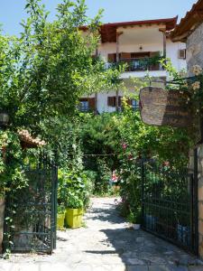 una puerta a un jardín con flores y un edificio en Arhontiko, en Psarádes