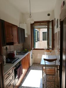 a kitchen with wooden cabinets and a table and a window at Appartamento Sant'Elena in Venice