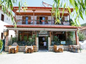 Arhontiko في Psarades: مطعم فيه طاولات وكراسي امام مبنى