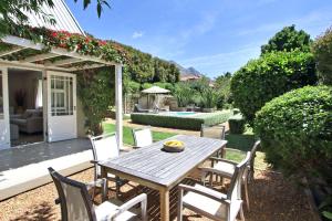 a patio with a table and chairs and a pool at Almondbury Cottage in Tokai