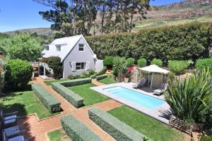a garden with a swimming pool and a house at Almondbury Cottage in Tokai