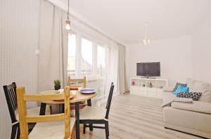 a living room with a wooden table and a dining room at Przy Piastowskiej in Gdańsk