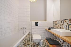 a bathroom with a toilet and a sink and a tub at Przy Piastowskiej in Gdańsk +9 photos