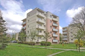 a tall apartment building with trees in front of it at Przy Piastowskiej in Gdańsk