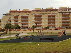 einen Spielplatz vor einem großen Apartmenthaus in der Unterkunft Apartment in South Aguadulce - Beach in Aguadulce