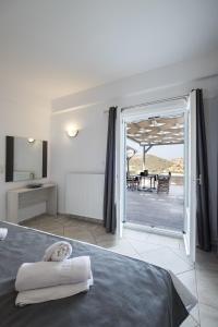a bedroom with a bed and a view of a patio at Paros Villas Nereids in Parikia