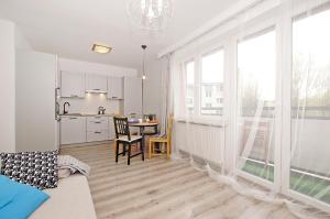 a living room with a kitchen and a table with chairs at Przy Piastowskiej in Gdańsk