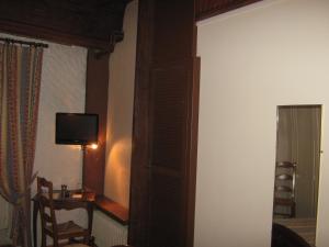 Zimmer mit einer Tür, die zu einem Zimmer mit einem TV führt. in der Unterkunft Hotel Chaumiere - in Tournon-sur-Rhône