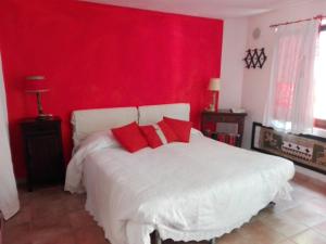 Dormitorio rojo con cama blanca y almohadas rojas en Bed & Relax Sinestesia, en Precicchie