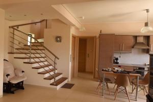 a living room with a spiral staircase and a kitchen at Panelma Villa Tranquil Coastal Retreat in Zacharo in Tholón