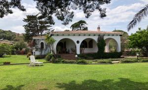 a white house with a lawn in front of it at Villa Margherita in Cannigione
