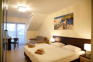 a bedroom with a bed with two towels on it at Willa Cztery Brzozy Chałupy in Chałupy
