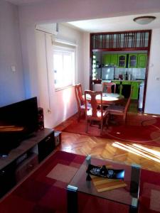 a living room with a table and a kitchen at CasaBlanca in Trebinje