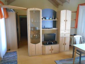 ein Wohnzimmer mit einem Entertainment-Center mit einem TV in der Unterkunft Fewo-Sendelbach in Greußenheim