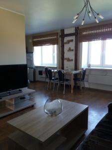 uma sala de estar com uma televisão e uma mesa e cadeiras em Grau Apartments 26 em Pärnu
