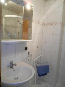 La salle de bains blanche est pourvue d'un lavabo et d'un miroir. dans l'établissement Fewo-Sendelbach, à Greußenheim