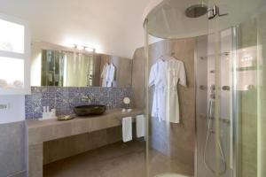 a bathroom with a shower and a sink at Santorini Secret Suites & Spa, Small Luxury Hotels of the World in Oia