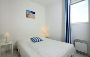 Un dormitorio blanco con una cama y una ventana. en Résidence Belle Dune Blanche, maisons et appartements, en Biscarrosse-Plage