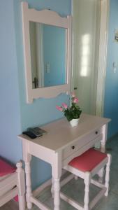 a white dressing table with a mirror and flowers on it at Bella Vista in Nydri