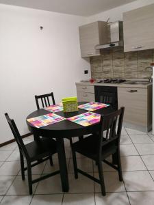 uma mesa de jantar e cadeiras numa cozinha em BORGO VOLCIANO GARDA LAKE APP.2 em Roe