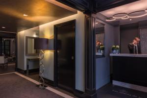 a lobby with a bar and a man in a mirror at Les Jardins De La Villa in Paris