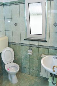 La salle de bains est pourvue de toilettes, d'un lavabo et d'une fenêtre. dans l'établissement Apartments Toska, à Rab
