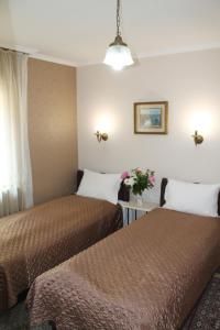 a hotel room with two beds and a window at Royal Family in Niš