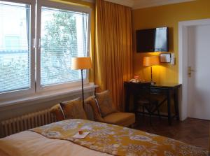 a hotel room with a bed and a chair and a window at Boutique Hotel Sir & Lady Astor - The Charming City Hotels in Düsseldorf +59 photos