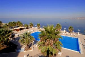 una vista aerea di un resort con piscina e palme di Dioscuri Bay Palace a San Leone