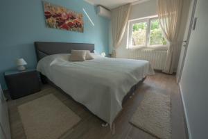 a bedroom with a large white bed with a window at Villa Sunset in Jadranovo +24 photos