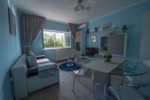 uma sala de estar azul com uma mesa e um sofá em Villa Sunset em Jadranovo